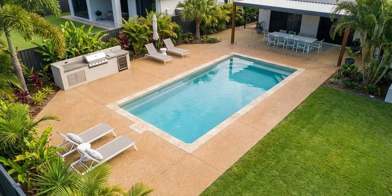 Aerial view of residential pool with generous exposed aggregate concrete surround and integrated entertaining area Gold Coast